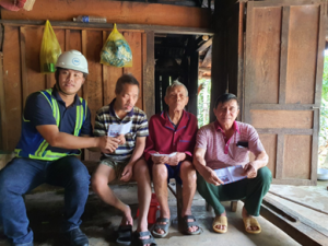 An engineer sitting with a group of man suffering from the flood in the Central Area